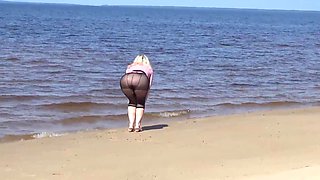 Jokey cougar with nylon caboose and breasts on beach