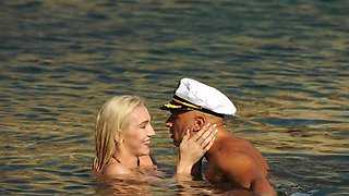 A girl with big boobs is having fun on the beach with her boyfriend.