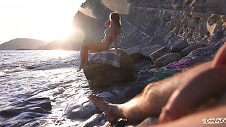 Breathtaking girl with a perfect body masturbates her pussy on a beach while stranger is jerking off on her